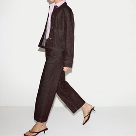 Model wearing Jigsaw burgundy cropped jacket and wide-leg trousers, styled with a pink shirt and black strappy kitten heels