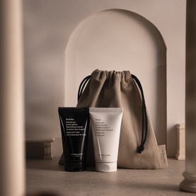 Jo Malone Care Collection Purify & Revitalise Duo with black and white tubes alongside a beige linen drawstring bag