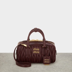 Miu Miu bordeaux quilted leather crossbody bag with gold-tone hardware, top handles, zip closure, and matching luggage tag charm