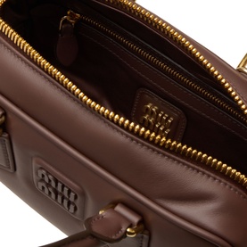 Miu Miu Radica brown leather crossbody bag, open interior view with gold-tone zip and embossed logo patch