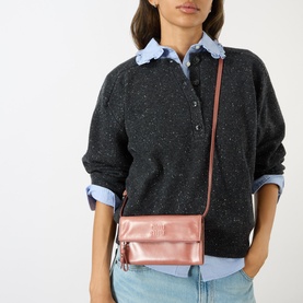 Model carrying Miu Miu Vitello Shine Mini Crossbody Bag in Antico metallic pink, silver-tone hardware, worn crossbody over dark knit sweater