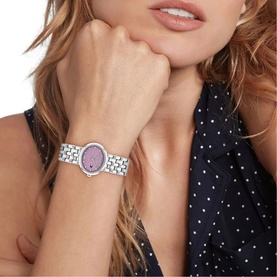 Model with Tommy Hilfiger silver-tone watch featuring purple glitter dial and crystal-set bezel, on metal bracelet strap