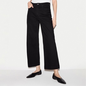 Model wearing Jigsaw black wide-leg cropped jeans with black pointed-toe ballet flats