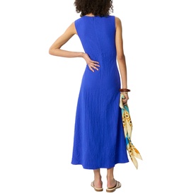 Model wearing Whistles blue sleeveless midi dress with textured pleated fabric, shown from behind, holding a printed silk scarf