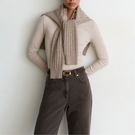 Model wearing Reiss mushroom brown cable-knit scarf, styled with matching fine-knit top and dark grey jeans with gold-buckle belt.