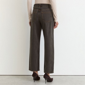 Model wearing Reiss mushroom brown wide-leg jeans, back view, styled with a cream top and dark heels.