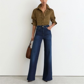 Model wearing Reiss dark blue wide-leg jeans, styled with an olive shirt and brown shoulder bag.