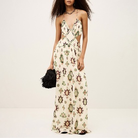 Model wearing Bash cream maxi dress with geometric ikat print, V-neckline, spaghetti straps and cut-out waist detail, styled with black clutch bag