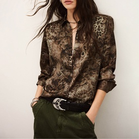 Model wearing Bash green animal print long-sleeve blouse, styled with a black belt and khaki trousers