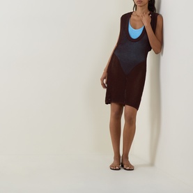Model wearing Bond Eye walnut dress over blue swimsuit, sleeveless mini length, with tan flat sandals