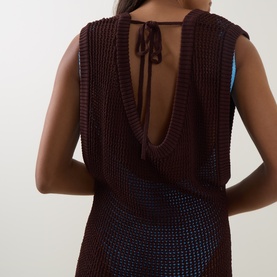 Model wearing Bond Eye walnut knit dress, rear view showing deep open back with tie detail at neckline