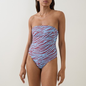Model wearing Bond Eye swimsuit in blue zebra and ruby print, strapless bandeau style with ruched detail.