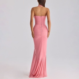 Model wearing House of CB raspberry halterneck ruched maxi dress, backless design, figure-hugging silhouette with flared hem