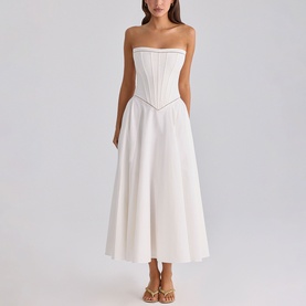 Model wearing House of CB white strapless corset midi dress with A-line skirt, styled with tan heeled sandals