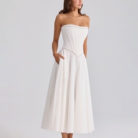 Model wearing House of CB white strapless corset midi dress with full A-line skirt and side pockets
