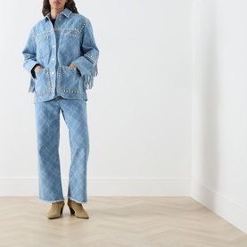 Model wearing Hayley Menzies blue diamond-jacquard jeans with matching fringed denim jacket and tan ankle boots.
