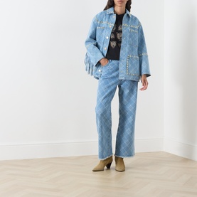 Model wearing Hayley Menzies blue denim jacket with studded detailing, styled with matching wide-leg jeans and khaki heeled boots.
