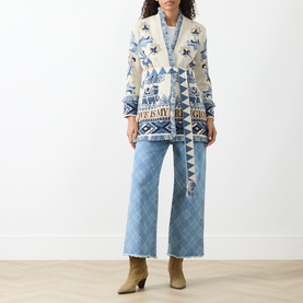 Model wearing Hayley Menzies Nandita Jaquard Wrap Cardigan in blue with fringe trim and jacquard pattern, styled with wide-leg jeans