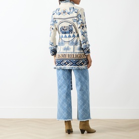 Model wearing Hayley Menzies Nandita Jacquard Wrap Cardigan in blue with elephant and palm print, styled with wide-leg jeans and brown ankle boots.