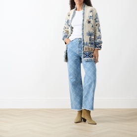 Model wearing Hayley Menzies Nandita Jacquard Wrap Cardigan in blue with elephant and palm tree print, styled with light-wash jeans and beige ankle