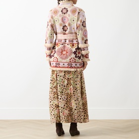 Model wearing Hayley Menzies ecru cotton floral knit jacket, back view, styled with a printed midi skirt and dark boots
