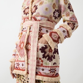 Model wearing Hayley Menzies ecru cotton knit cardigan with geometric folk print, fringe trim cuffs and tie belt, midi length.