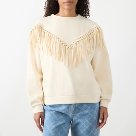 Model wearing Hayley Menzies Sabina Fringe Sweatshirt in ecru with chevron faux-suede fringing and gold eyelets, styled with blue jeans