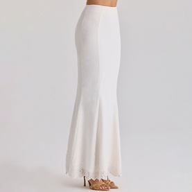 Model wearing House of CB white maxi skirt with lace hem detail, styled with strappy heeled sandals