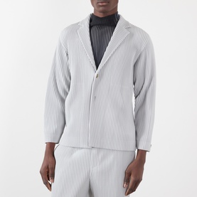 Model wearing Issey Miyake Pleated Single-Breasted Blazer in grey, notched collar, single-breasted, styled with matching pleated trousers.