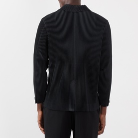 Model wearing Issey Miyake black pleated polyester blazer, back view showing textured ribbed finish and long sleeves.