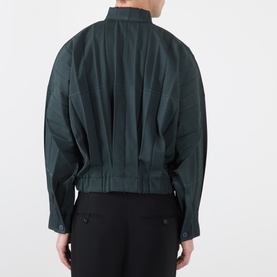 Model wearing Issey Miyake Dark Green casual shirt, rear view, showing structured pleated back and mandarin collar, styled with black trousers.