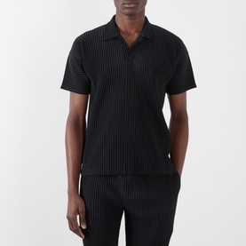 Model wearing Issey Miyake Open Collar Pleated Polo Shirt in black, styled with matching black pleated trousers