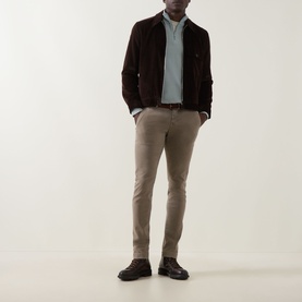 Model wearing Jacob Cohen Bobby Slim Leg Chinos in Elephant Grey, styled with a dark brown suede jacket and light blue shirt.