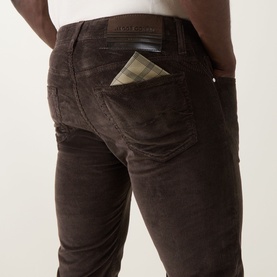 Model wearing Jacob Cohen Bard Corduroy Straight Leg Trousers in brown, rear view showing leather logo patch and check-lined pocket.