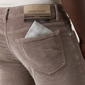 Model wearing Jacob Cohen Elephant Grey corduroy trousers, close-up of back pocket with branded label and pocket square detail.