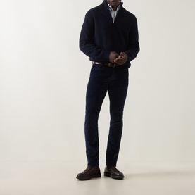Model wearing Jacob Cohen Bard Corduroy Straight Leg Trousers in Night Blue, styled with navy half-zip knit and brown leather shoes.