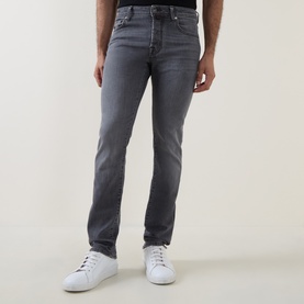 Model wearing Jacob Cohen 3049 slim jeans in medium black denim, styled with white low-top trainers