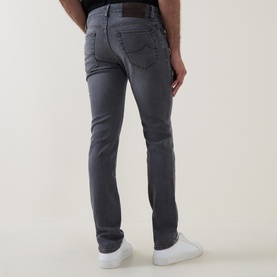 Model wearing Jacob Cohen 3049 slim jeans in 600D Medium Black denim, shown from behind, styled with white trainers