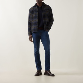 Model wearing Jacob Cohen Bard Slim Leg Jeans in medium blue with tobacco stitching, styled with dark check overshirt and brown leather shoes.