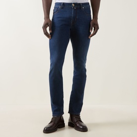 Model wearing Jacob Cohen Bard Slim Leg Jeans in medium blue with tobacco stitching and whiskering details, styled with brown leather boots.