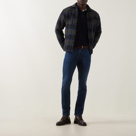 Model wearing Jacob Cohen Bard Slim Leg Jeans in Medium Blue, styled with a navy checked overshirt and brown leather shoes.