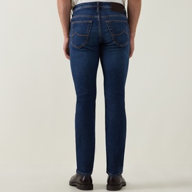 Model wearing Jacob Cohen 3049 slim jeans in dark blue denim, rear view showing back pockets and tailored fit