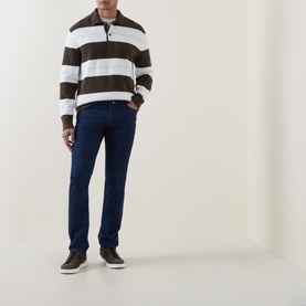 Model wearing brown and white stripe half-zip knit sweater, styled with dark navy jeans and brown suede trainers.