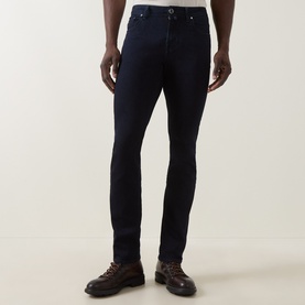 Model wearing Jacob Cohen 3049 slim jeans in dark blue, styled with brown leather lace-up boots.
