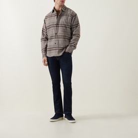 Model wearing Jacob Cohen 3049 Slim Jeans in Dark Blue, styled with a grey plaid overshirt and navy trainers.