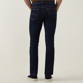 Model wearing Jacob Cohen 3049 slim jeans in dark blue, rear view showing five-pocket styling and contrast stitching detail.