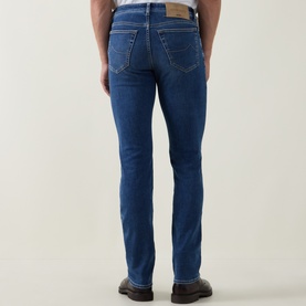 Model wearing Jacob Cohen 3049 Slim Jeans in light blue denim, rear view showing back pockets with tan leather patch detail.