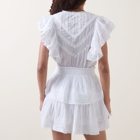Model wearing LOVESHACKFANCY Gwen Heritage Mini Dress in white, back view showing flutter sleeves, lace embroidery, elasticated waist and tiered