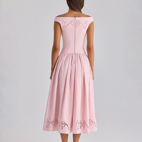 Model wearing House of CB pink off-shoulder midi dress with full pleated skirt and floral cutwork hem detail, shown from the back.