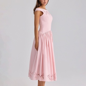 Model wearing House of CB pink midi dress with off-shoulder neckline, gathered skirt and floral cutwork hem detail.